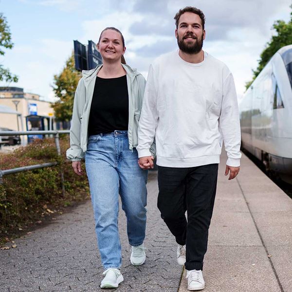 En kvinde og mand går hånd i hånd
