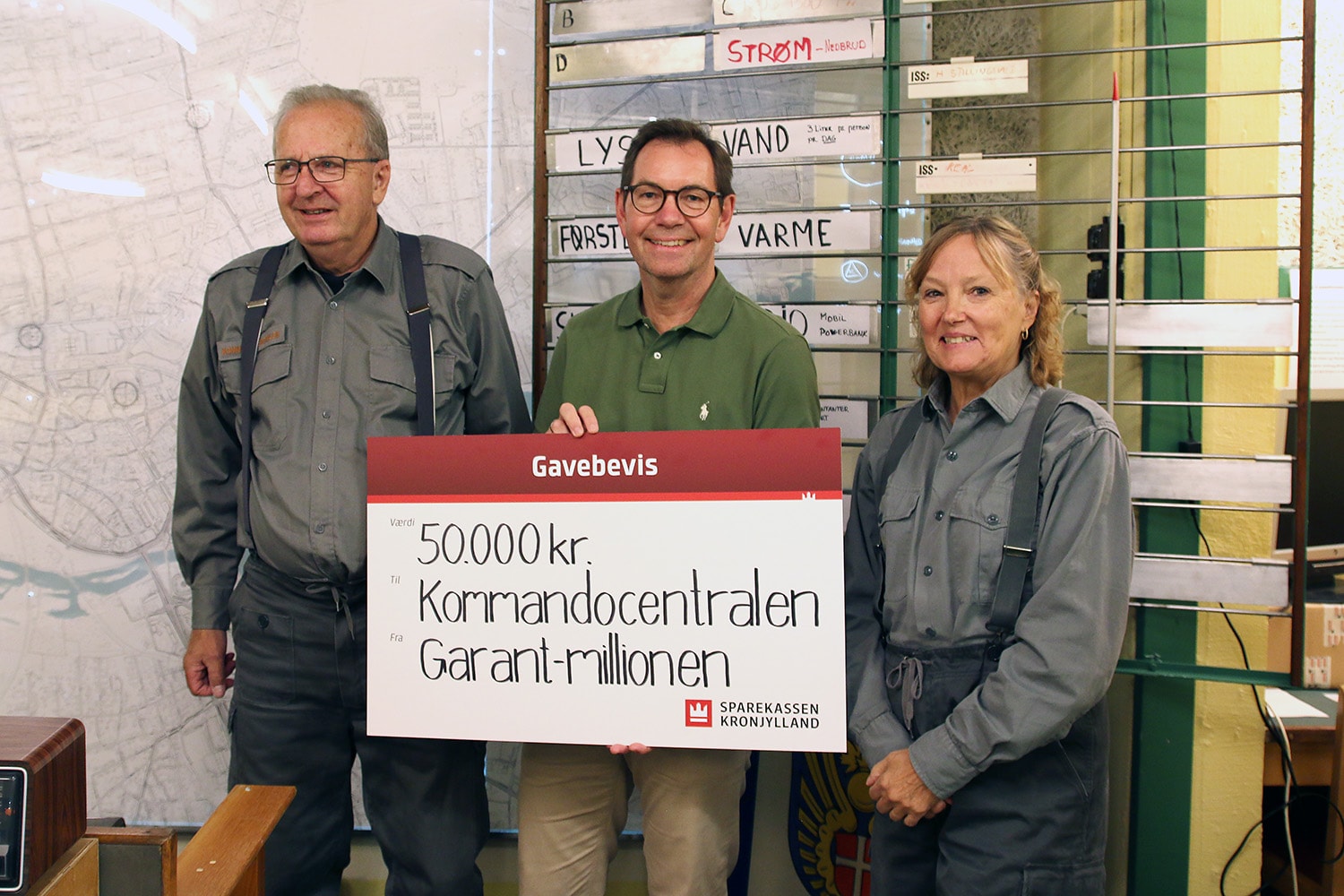Afdelingsdirektør Jan Nyvang fra Sparekassen Kronjylland overrækker donationen til de frivillige, der holder liv i historien i den gamle koldkrigsbunker.